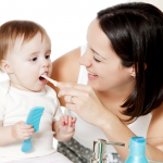 Ребенок чистит зубы под присмотром взрослых